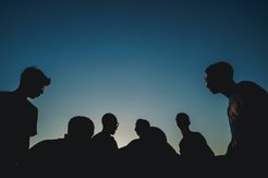 Die Silhouetten von mehreren Personen in der Dämmerung