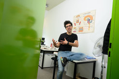 Mehdi Moussaid auf einem Bürotisch sitzend und mit den Händen gestikulierend