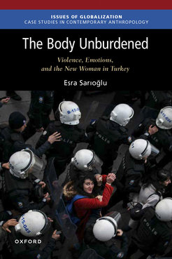 It shows the Book Cover The Body Unburdened written by Esra Sarioglu. The upper third displays the book title and name, in the lower two thirds is a photo of a woman standing in the midst of police officers and the proud look is led away.