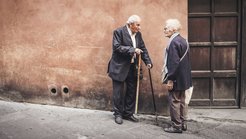 Ein älteres Paar steht an einer Wand und unterhält sich