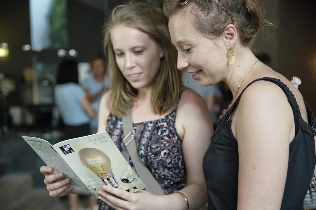 The photo shows two people reading together.