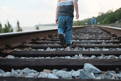 Zwei Kinder laufen Schienen entlang