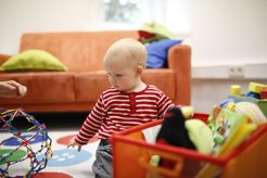 Dieses Bild zeigt ein Kleinkind im BabyLab, das mit Spielzeug spielt.